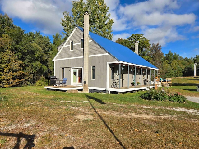 back of house featuring a wooden deck and a lawn