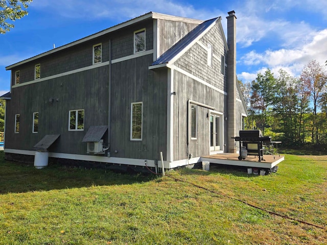 back of house with a wooden deck and a lawn