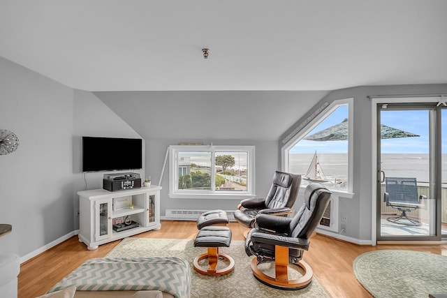 living room with lofted ceiling, a water view, and light hardwood / wood-style flooring