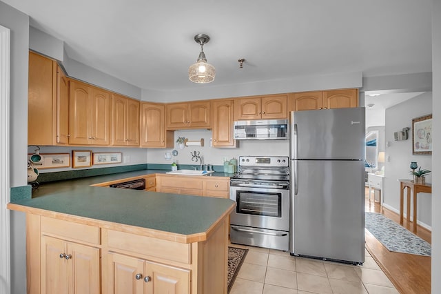 kitchen with light wood-type flooring, sink, kitchen peninsula, stainless steel appliances, and decorative light fixtures