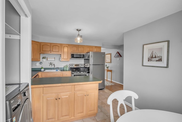 kitchen with appliances with stainless steel finishes, independent washer and dryer, light tile patterned floors, light brown cabinetry, and decorative light fixtures