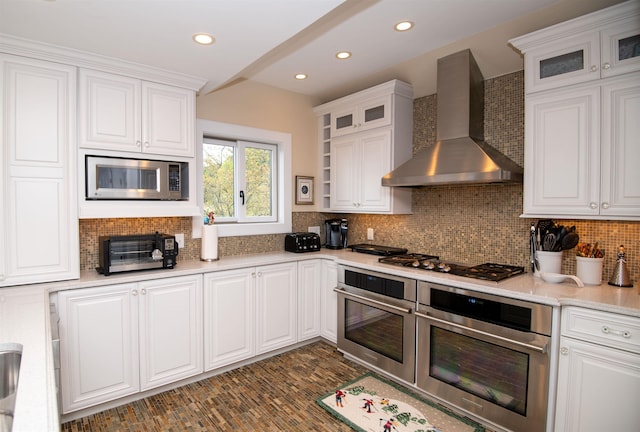 226 Okemo Trailside Ext Unit 47C, Ludlow, VT 05149 - kitchen with wall chimney exhaust hood, white cabinets, appliances with stainless steel finishes, and tasteful backsplash