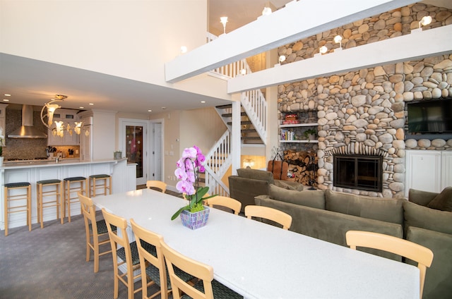 226 Okemo Trailside Ext Unit 47C, Ludlow, VT 05149 - carpeted dining area with stairway, recessed lighting, a fireplace, a towering ceiling, and a notable chandelier