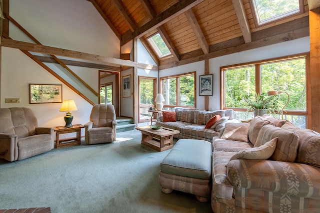 carpeted living room featuring high vaulted ceiling, a skylight, and a healthy amount of sunlight