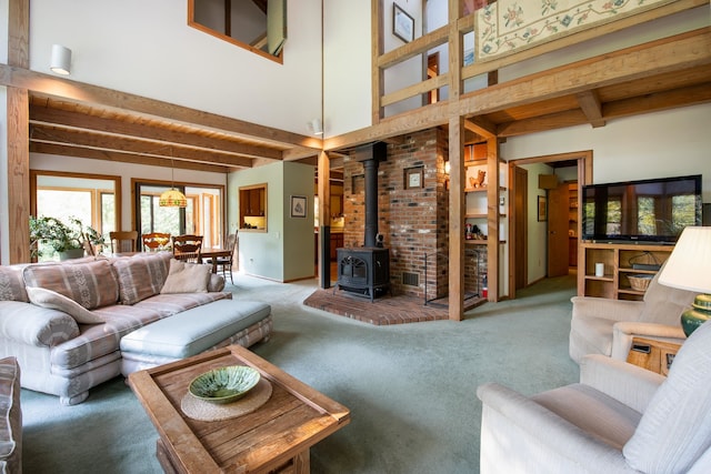 carpeted living room featuring beamed ceiling and a wood stove