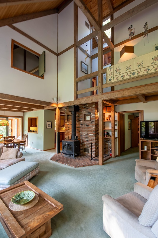 living room with high vaulted ceiling, a wood stove, beam ceiling, and carpet flooring