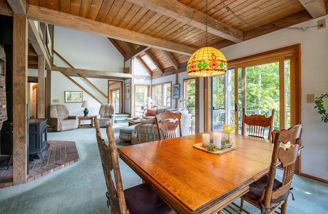 dining area with carpet floors, plenty of natural light, and a wood stove