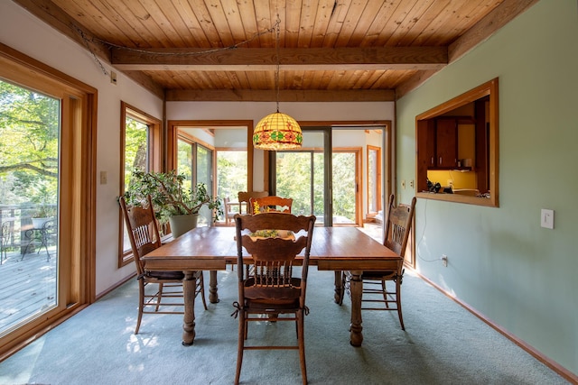 carpeted dining space with beam ceiling and wooden ceiling