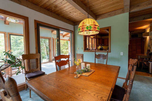 dining room with carpet, beamed ceiling, and wooden ceiling