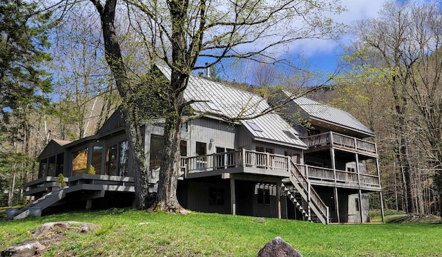 rear view of house featuring a yard and a wooden deck