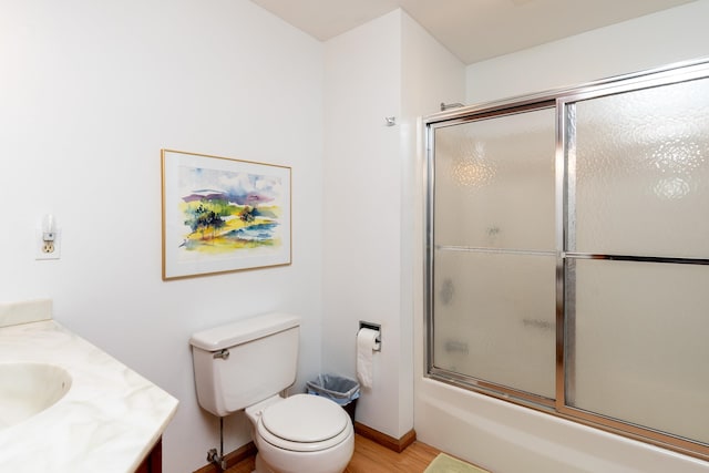 full bathroom with shower / bath combination with glass door, vanity, toilet, and hardwood / wood-style flooring