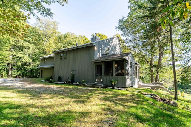 rear view of house featuring a yard and a sunroom