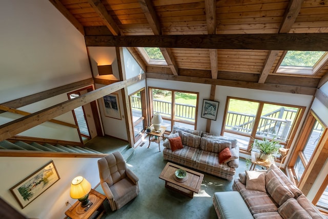 living room featuring beamed ceiling, a skylight, and a wealth of natural light