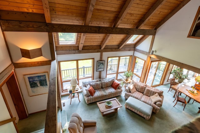 living room featuring carpet flooring, beam ceiling, high vaulted ceiling, a skylight, and wooden ceiling