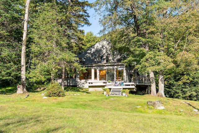 rear view of house with a deck and a yard