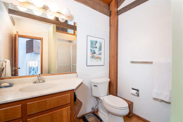 bathroom with vanity, toilet, and a shower with door