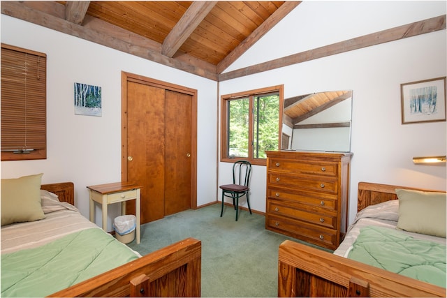 carpeted bedroom with lofted ceiling with beams, a closet, and wooden ceiling