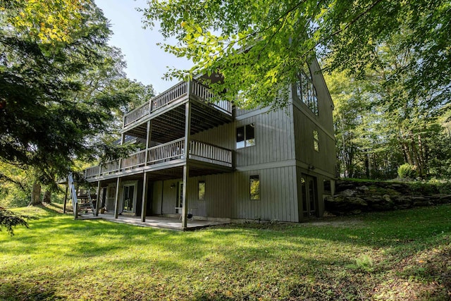 rear view of house featuring a lawn, a deck, and a patio area