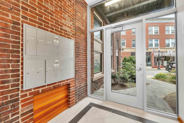 entryway with mail boxes, light tile patterned floors, and a wealth of natural light