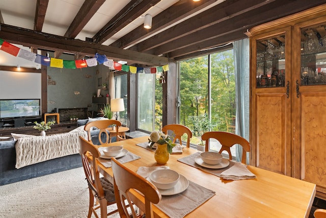 dining space featuring beamed ceiling