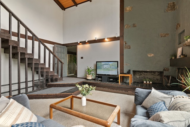 living room featuring carpet floors, beamed ceiling, high vaulted ceiling, and wooden ceiling