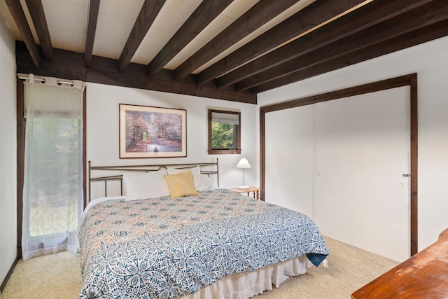 carpeted bedroom with beamed ceiling