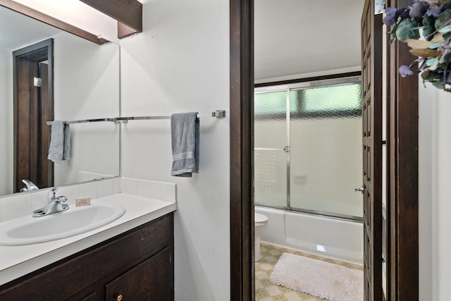 full bathroom with toilet, vanity, and combined bath / shower with glass door