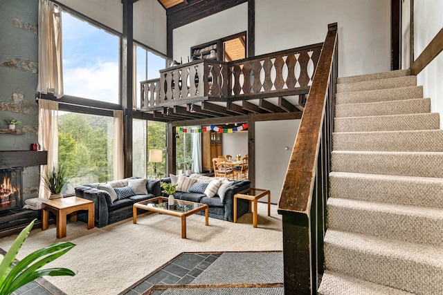 living room with a towering ceiling and carpet flooring