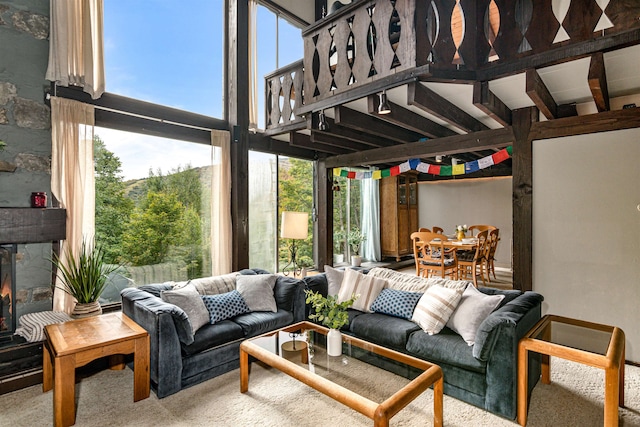 carpeted living room with a high ceiling and a fireplace