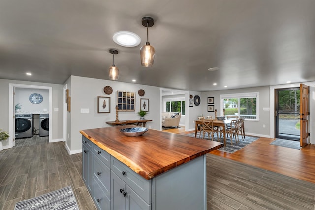 kitchen with hanging light fixtures, butcher block counters, gray cabinets, washer and clothes dryer, and dark hardwood / wood-style floors