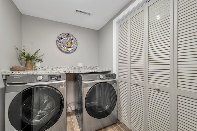 washroom with washer and clothes dryer and wood-type flooring