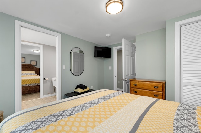 bedroom featuring connected bathroom, light hardwood / wood-style floors, and a closet