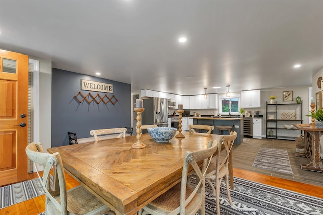 dining space with wine cooler and hardwood / wood-style flooring