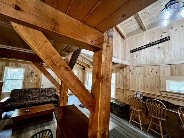 interior space featuring wood ceiling, wood finished floors, wooden walls, and beam ceiling