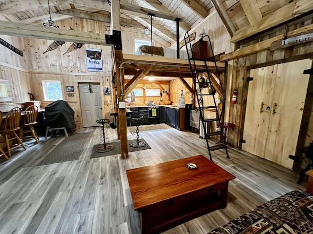 living room with high vaulted ceiling, wood ceiling, beam ceiling, wooden walls, and light wood-style floors