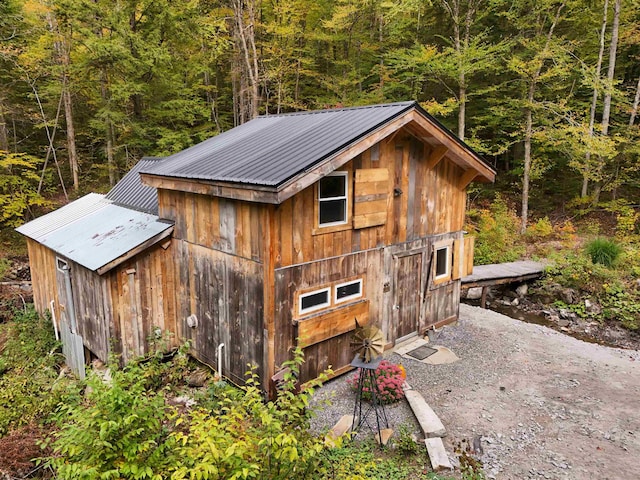 view of outbuilding featuring an outdoor structure and a wooded view
