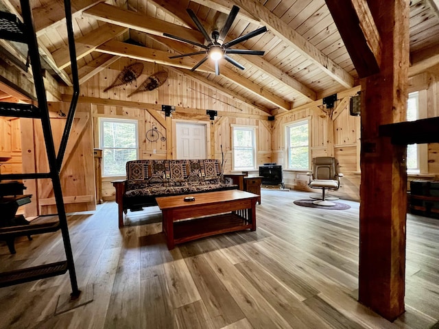 living room with vaulted ceiling with beams, wooden walls, wooden ceiling, and wood-type flooring
