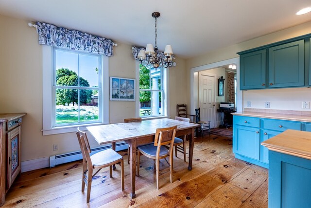 dining space with light hardwood / wood-style flooring and a notable chandelier