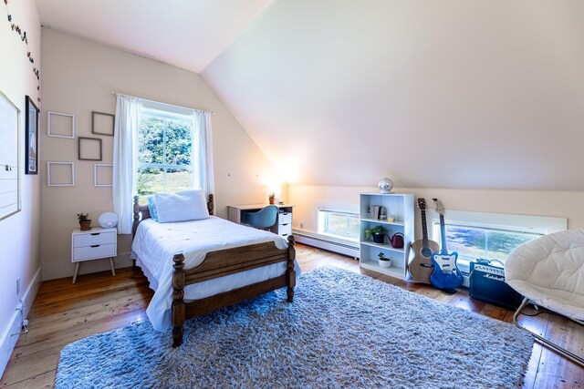 bedroom with multiple windows, lofted ceiling, hardwood / wood-style floors, and a baseboard radiator