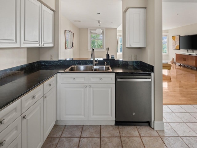 kitchen with stainless steel dishwasher, white cabinetry, sink, and a wealth of natural light