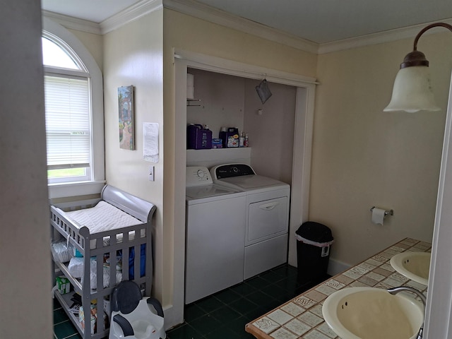 bathroom featuring independent washer and dryer, crown molding, a healthy amount of sunlight, and a sink