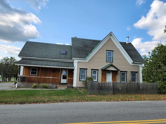 view of front of property featuring a front yard, roof with shingles, and a fenced front yard