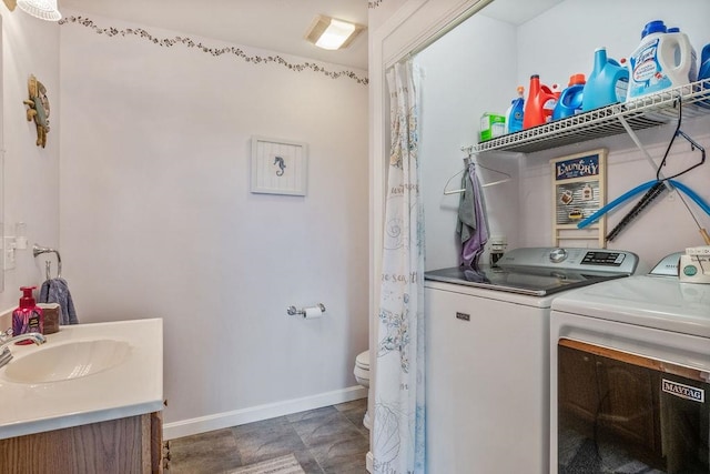 clothes washing area featuring sink and washer and dryer