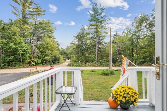 wooden terrace featuring a lawn