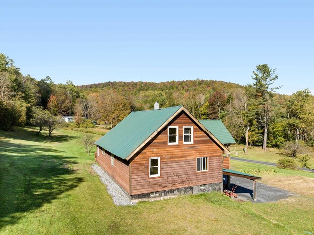 view of side of home featuring an outbuilding and a yard