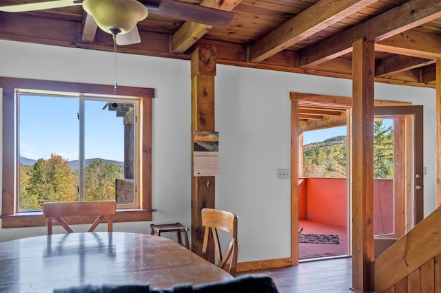 dining area featuring wood ceiling, beamed ceiling, a mountain view, ceiling fan, and hardwood / wood-style flooring