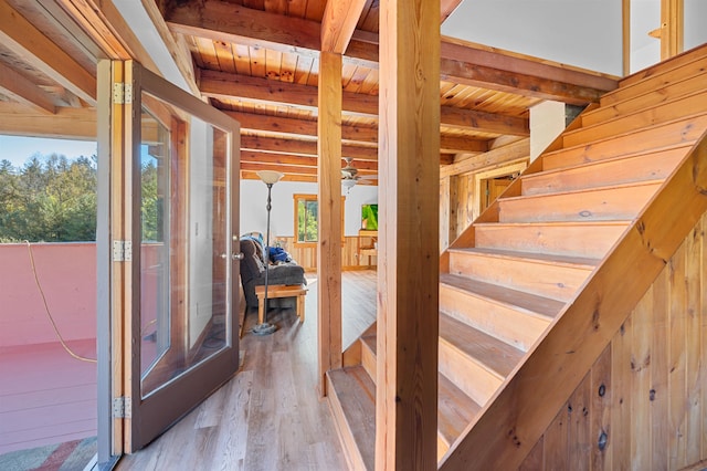 stairs with hardwood / wood-style flooring, beam ceiling, and wooden ceiling