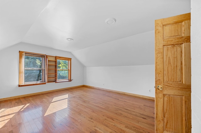 bonus room with lofted ceiling and hardwood / wood-style floors