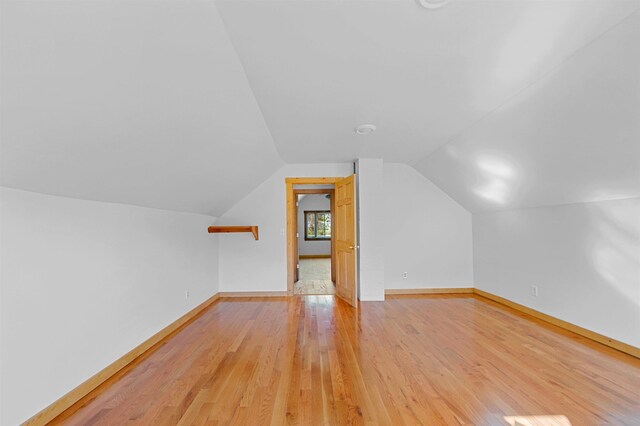 additional living space with lofted ceiling and light wood-type flooring