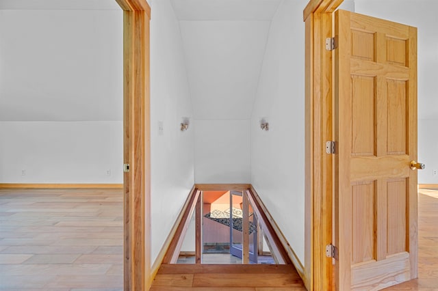 hall with light hardwood / wood-style floors and lofted ceiling